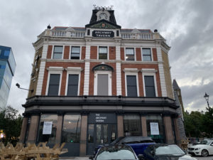 image of archway tavern, with its red and white features and an unused clock at the top