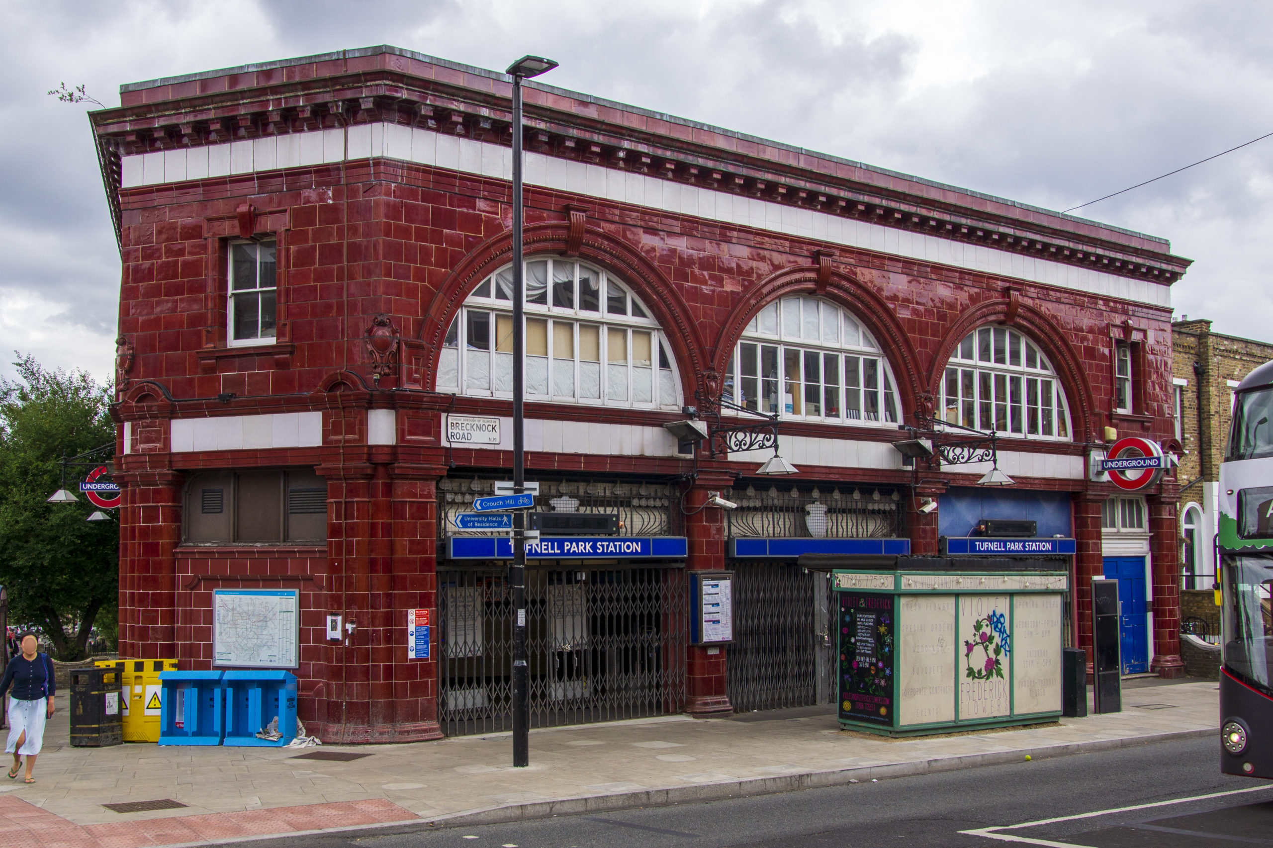 station building of Tufnell Park tube station. It has red tiles and three arches with white fillings and windows. It has a white trim line at the top.