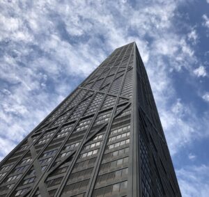 The John Hancock Centre, with its steel structure and reflecting windows against a cloudy, blue sky